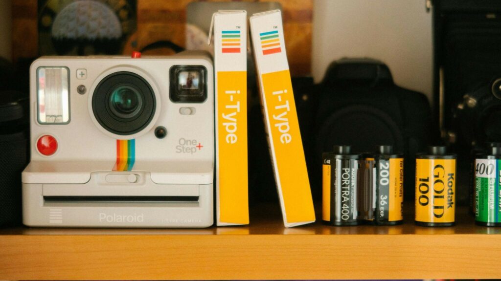 Миттєва камера на полиці поруч із плівкою i-Type та касетами Kodak і Fujifilm.
